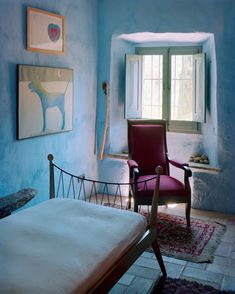 a bed room with a neatly made bed and a chair