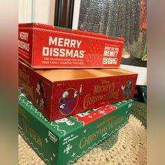 three merry dissmas boxes stacked on top of each other in front of a window