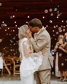 a bride and groom kissing in front of bubbles