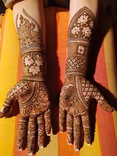 two hands with henna tattoos on them