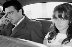 a man and woman sitting in the back seat of a car