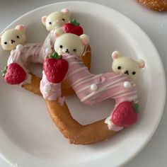 there are some cookies shaped like bears and strawberrys on top of each other in the shape of letters