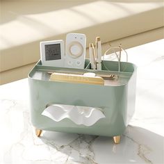 an electronic device and other items in a holder on a marble counter top with sunlight coming through the window