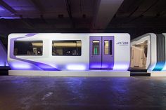 a train that is sitting in the middle of a building with lights on it's sides