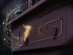 a close up of a wooden cabinet with lights on it and a fairy figurine