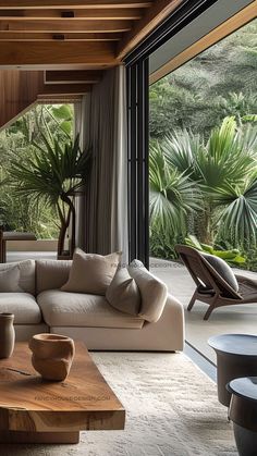 a living room filled with lots of furniture and plants on the wall next to it