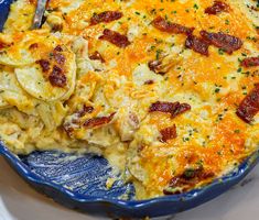 a casserole with bacon and cheese in a blue dish on a white plate