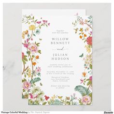 a wedding card with flowers and greenery on the front, featuring an ornate border