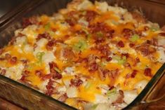 a casserole dish with bacon, cheese and green onions