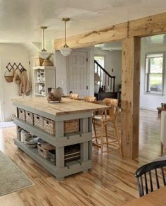 a kitchen island with baskets on it in the middle of a wooden floored room