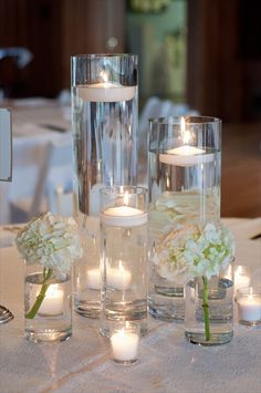 candles and flowers in glass vases on a table