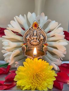 a white and yellow flower sitting next to a lit candle