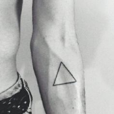 black and white photo of two people with tattoos on their legs, one has a triangle