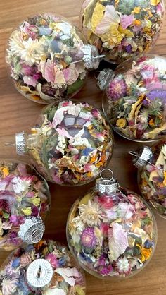 several glass ornaments with flowers in them on a table