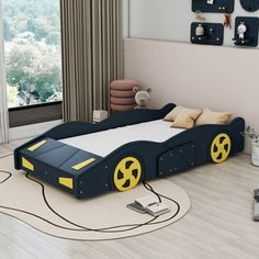 a child's bedroom with a race car bed in the middle and toys on the floor