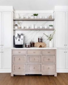 an instagramted photo of a kitchen with white cupboards and open shelving