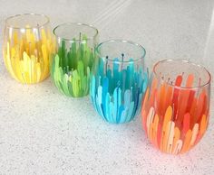 five colorful glasses sitting on top of a counter next to each other with different colors