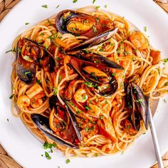 a plate of pasta with mussels and sauce