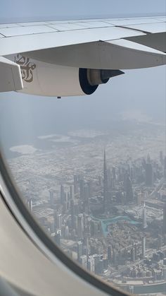 an airplane wing with the view of a city