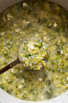 a ladle filled with broccoli and cheese soup