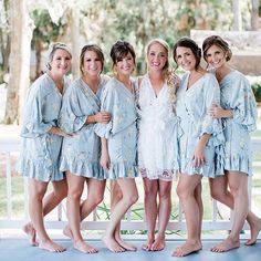 a group of women standing next to each other wearing blue robes and smiling at the camera