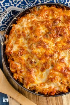 a cheesy casserole in a skillet on a wooden table