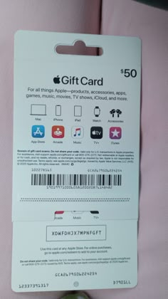 an apple sitting on top of a bed next to a pink sheet with the gift card attached