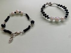 These bracelets are made with black and pearlescent beads to mimic the three moons in the night sky of Pyrrhia; Perfect for any FanWing who loves to say 'Three Moons!' There is a Wire Wrapped version and a Charm Bracelet style option. The wire wrapped has the appearance of two rows of black beads, while the Charm Bracelet Style is looser and only has one row of black beads. Description: Beads of different shapes and colors are linked together with wire. Jump rings are added so the bracelets are adjustable. Length: adjustable (for teen/adult wrists) Materials: Plastic and/or glass beads, metal wire Care instruction: do NOT shower with the bracelet on, metal and beads WILL tarnish Three Moons, Moon Bracelet, Bracelet Style, The Night Sky, Metal Wire, Jump Rings, Black Beads, Night Sky, Fashion Bracelets