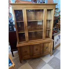 a wooden china cabinet with glass doors and drawers