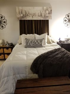 a bed with pillows and blankets on it in a bedroom next to two nightstands