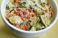 a white bowl filled with pasta and veggies covered in parmesan cheese