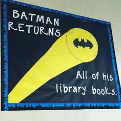 a batman themed library book banner hanging from the ceiling in front of a white wall