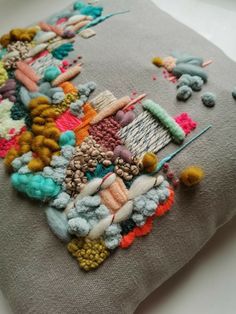 a close up of a pillow on a table with buttons and needles attached to it