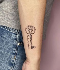 a person with a tattoo on their arm holding a key