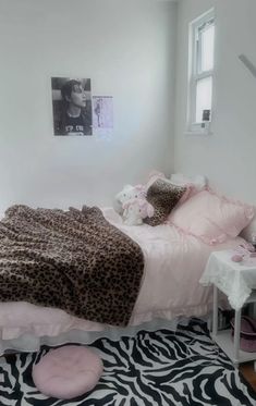 a bedroom with zebra print rug and pink bedding