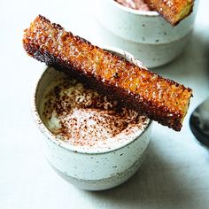 two small white bowls filled with food on top of a table