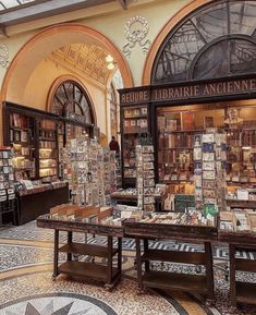 the inside of a book store with many books on tables and shelves full of books