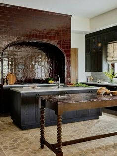 a kitchen with black cabinets and an island in front of the stove, countertop