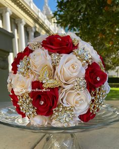 a bridal bouquet with brooches and jewels on it in front of a succulent plant