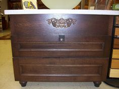 a wooden dresser with white marble top in a store