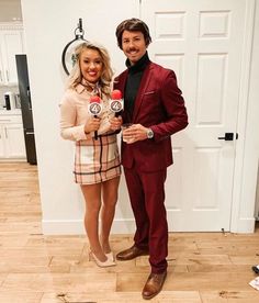 a man and woman standing next to each other in front of a door holding microphones