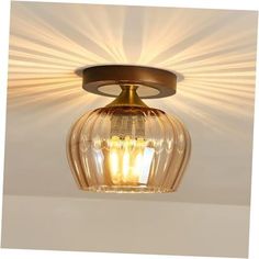 a close up of a light fixture on a ceiling with sun rays in the background