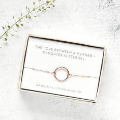 the love between a mother and daughter is eternal bracelet in gold filled box with greenery