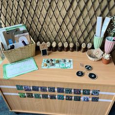 a wooden table topped with lots of pictures and magnets next to a basket filled with flowers