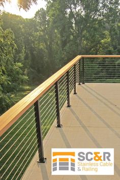 an outdoor deck with railings and handrails in the foreground, surrounded by trees