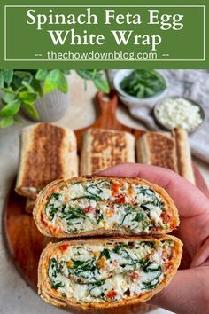 spinach feta egg white wrap is cut in half on a cutting board with other food