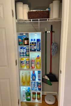 an open refrigerator with cleaning supplies and other items in the door way next to it