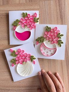 three handmade greeting cards with pink flowers and green leaves on them, one being held by a woman