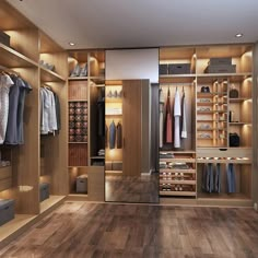 a large walk in closet with wooden floors