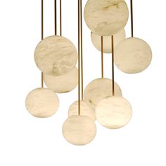 the light fixture is made from marble balls and brass rods, which are suspended by gold colored wires